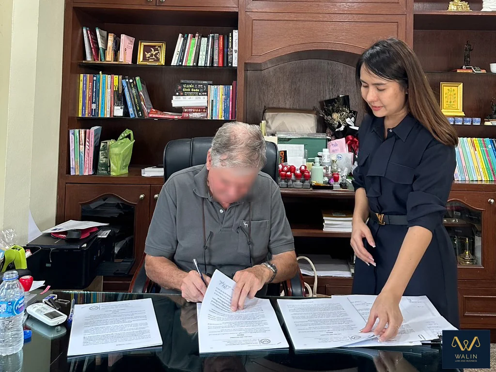 Walin assisting a client as documents are signed at the office